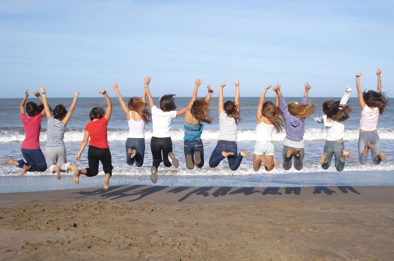 Alumnas de intercambio saltando en una playa de mar del plata