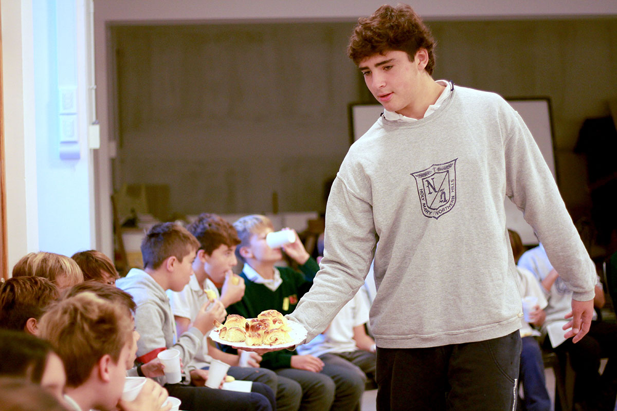 Alumno de 6to de secundaria repartiendo alimentos en el desayuno de bienvenida